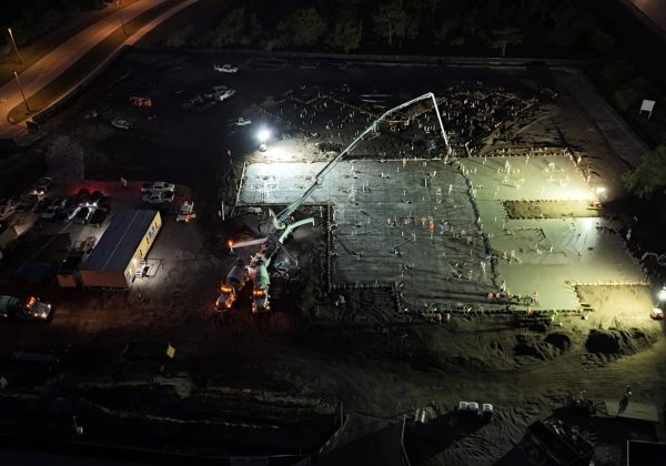 Aerial night view of a large commercial concrete slab pour under work lights